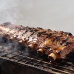 Grosse cote de boeuf grillee sur barbecue fumant