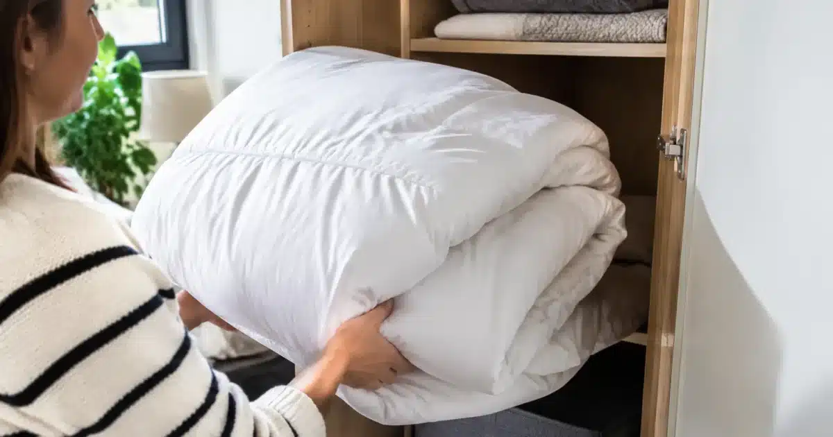 Couette pliée sortant d'un placard ouvert avant lavage
