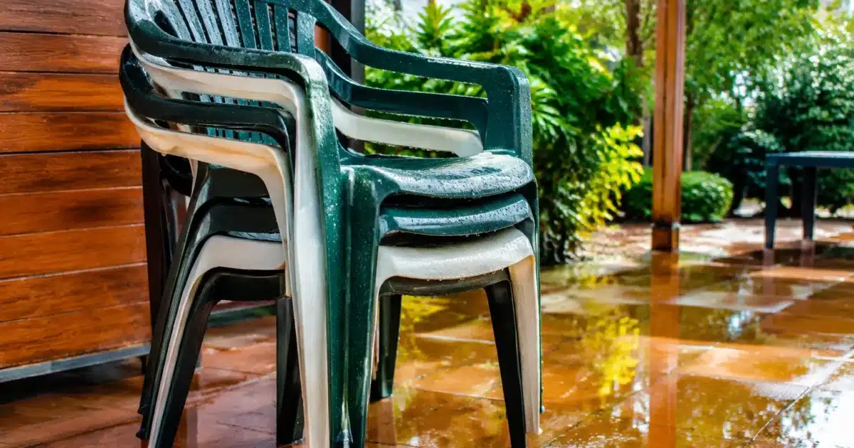 Chaises en plastique mouille empilees sur terrasse couverte d'eau