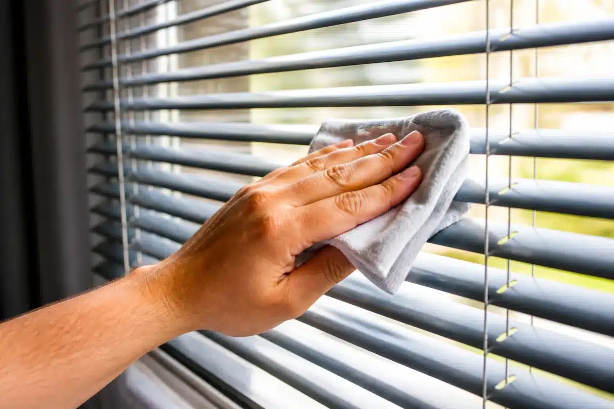 Main cleaning aluminum blind slats with dry cloth