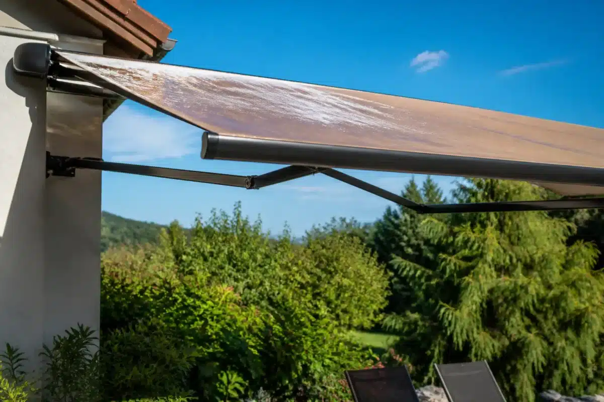 Store déployé au soleil, toile humide brillante